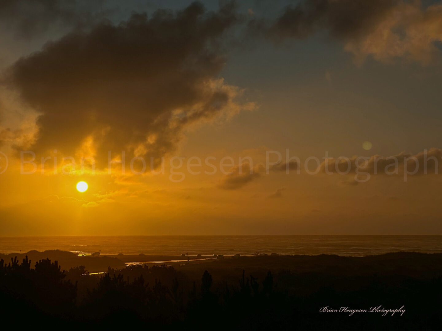 A sunset with the sun setting over the ocean.