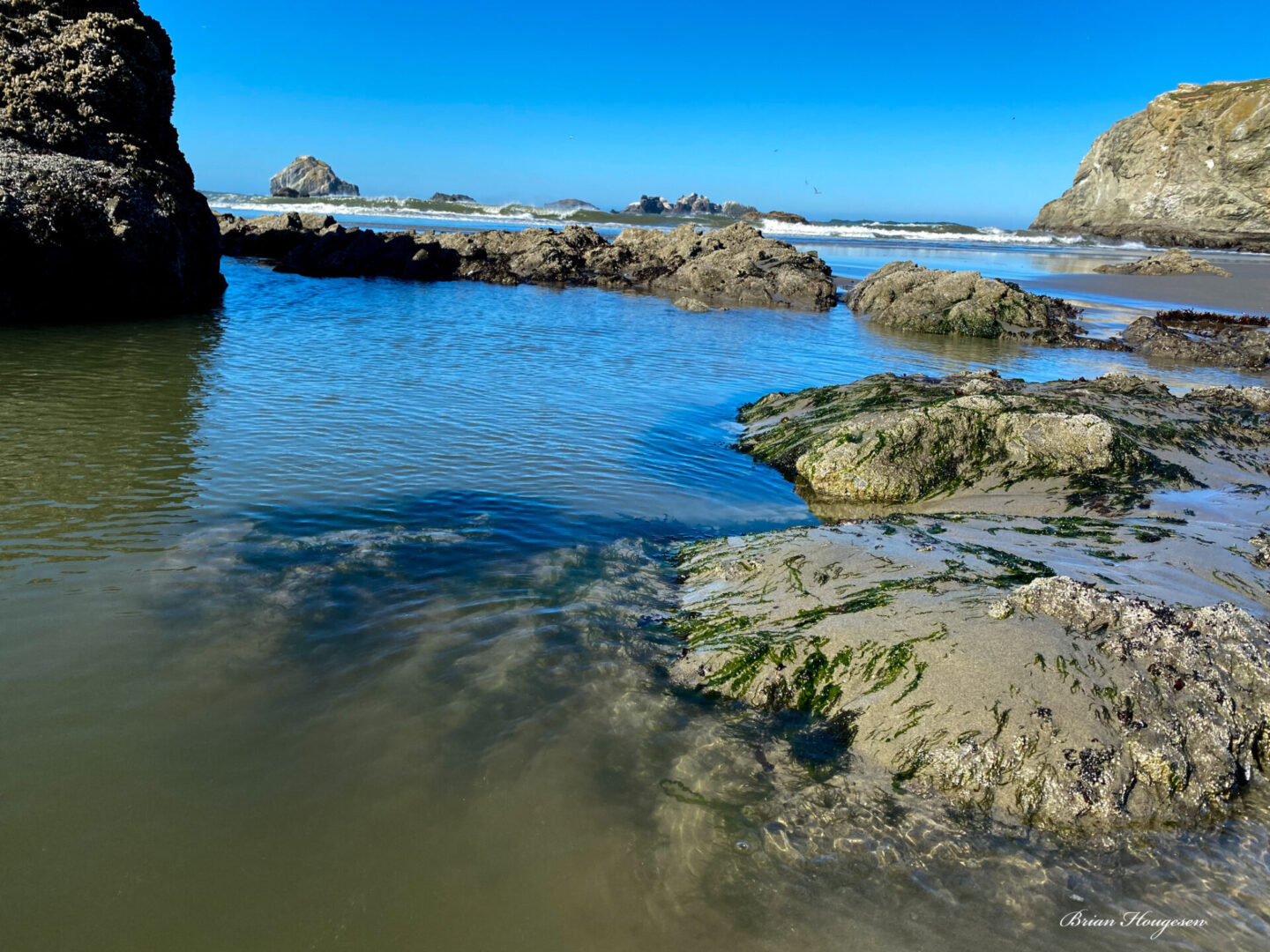 A body of water with rocks and sand on it