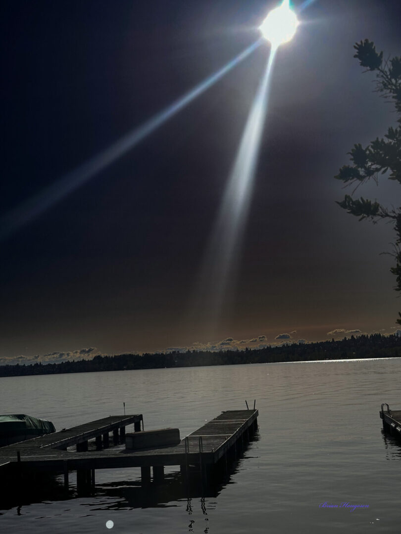 A boat dock on the water under a cloudy sky.