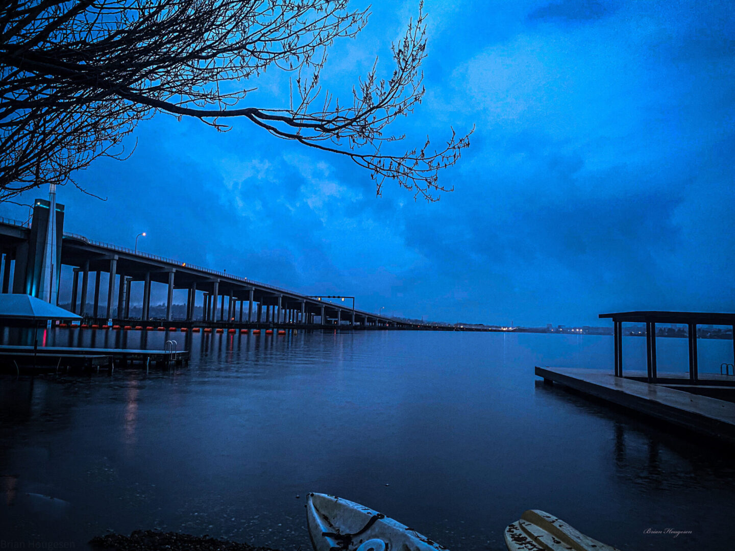 A pier with boats in the water at night.