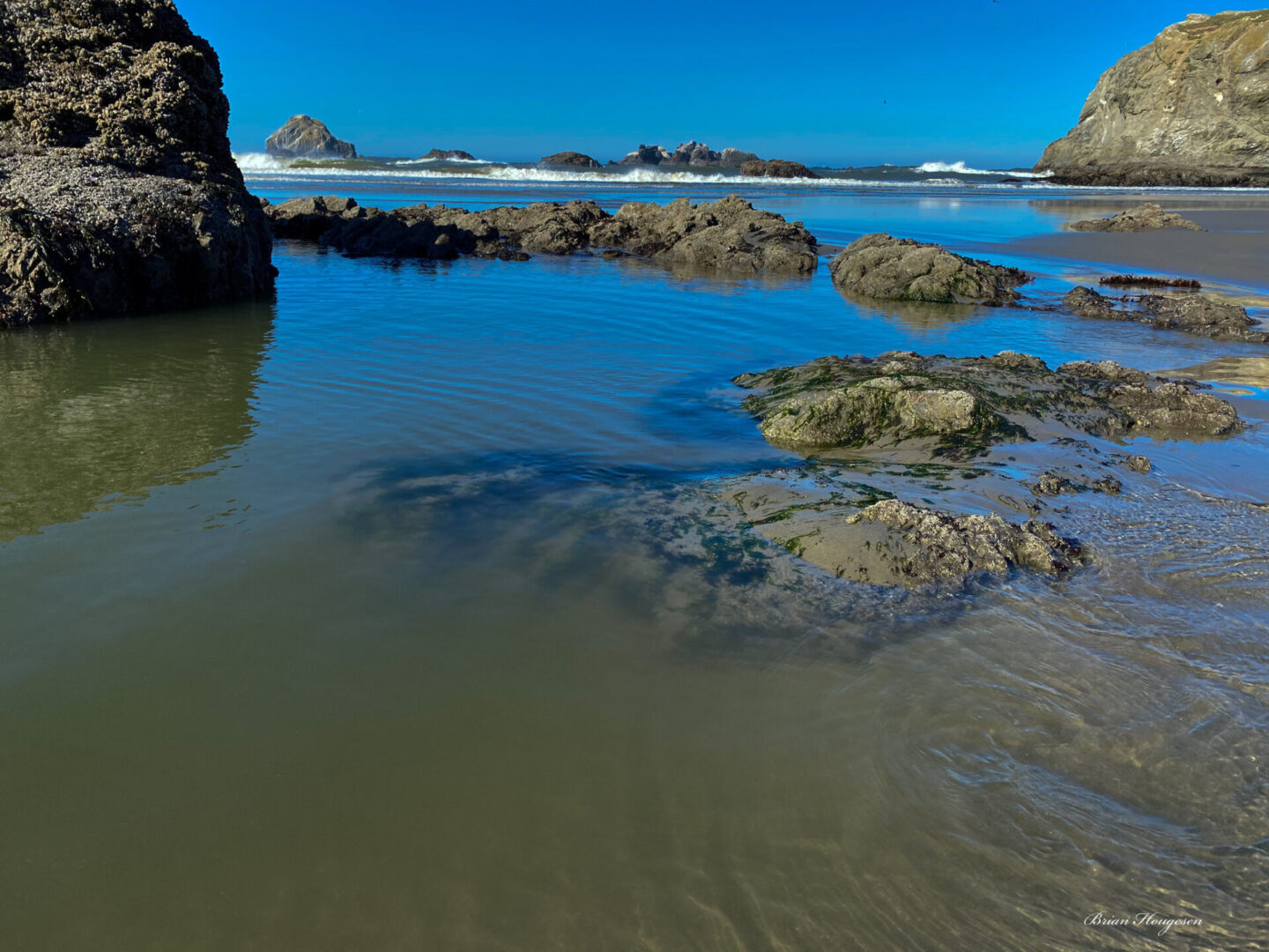 A body of water with rocks and sand on it