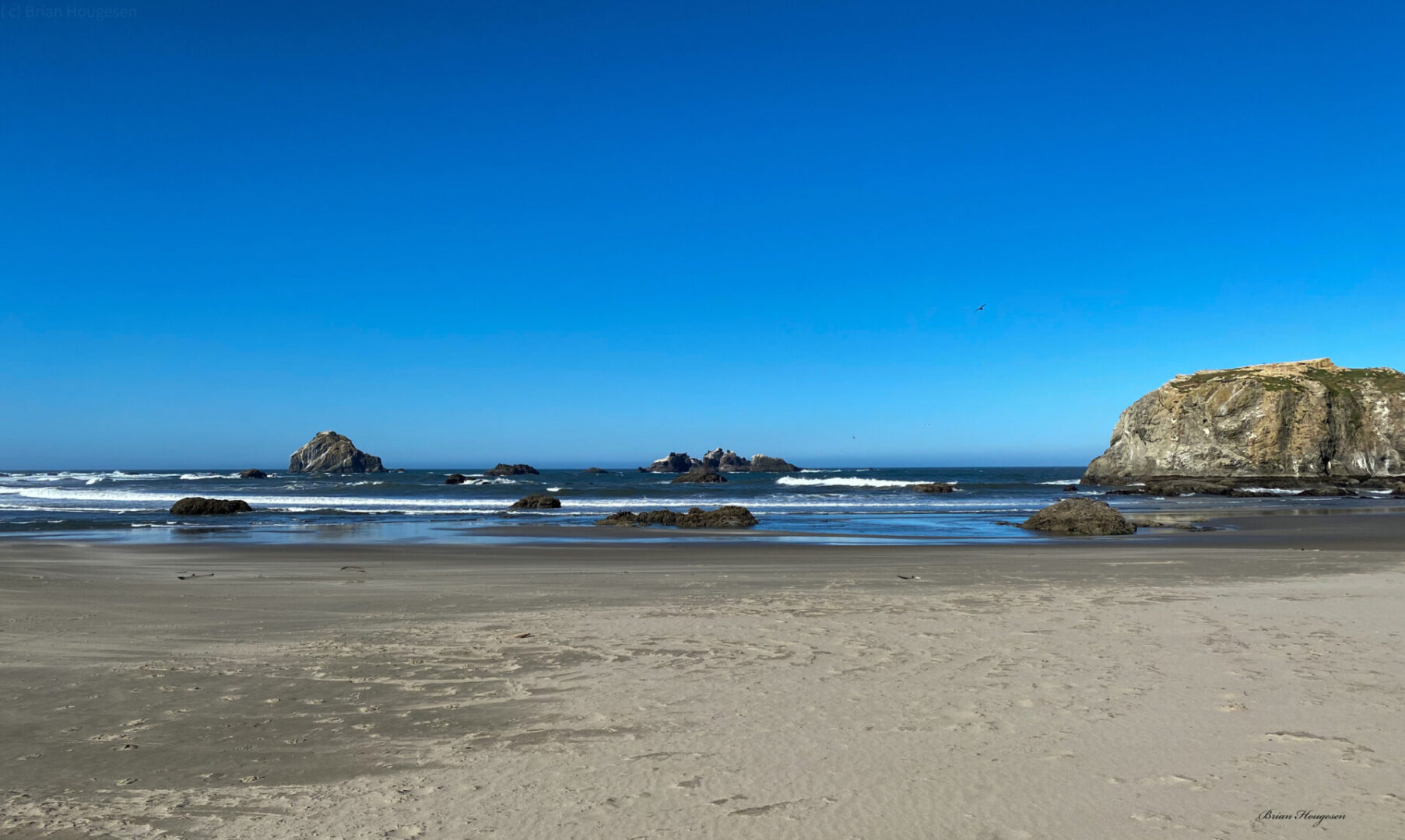 A beach with rocks and water in the background.