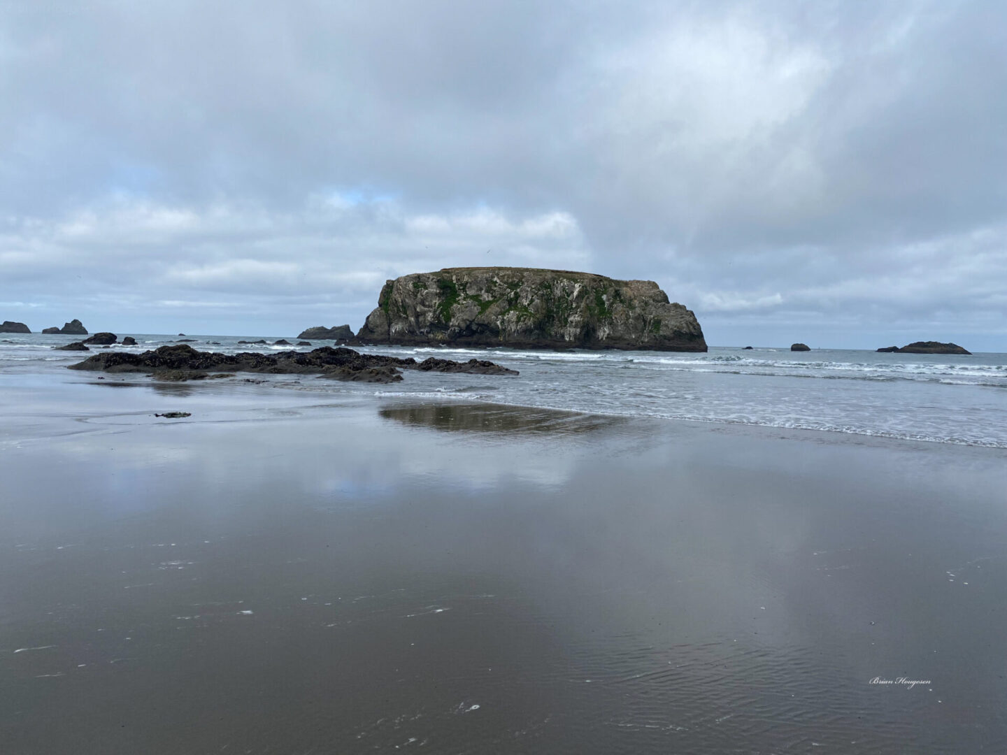 A rock formation in the distance is seen from the water.