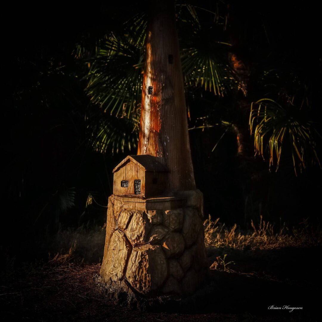 A tree stump with a house on top of it.